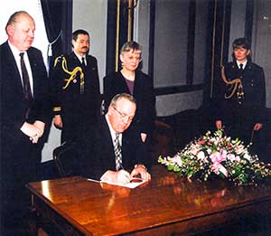 ﻿March 7, 1997 - Honourable John E.N. Wiebe Lieutenant Governor of Saskatchewan signs the proclamation of The Engineering and Geoscience Professions Act, attended by Heinrich Feldkamp, P.Eng., FEC (APES President 1996 – 1997) and Frances Haidl, P.Geo., FEC (Hon.), FGC (Act Amendment Committee)