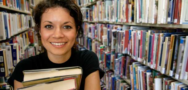 stock images smiling girl in library holding books